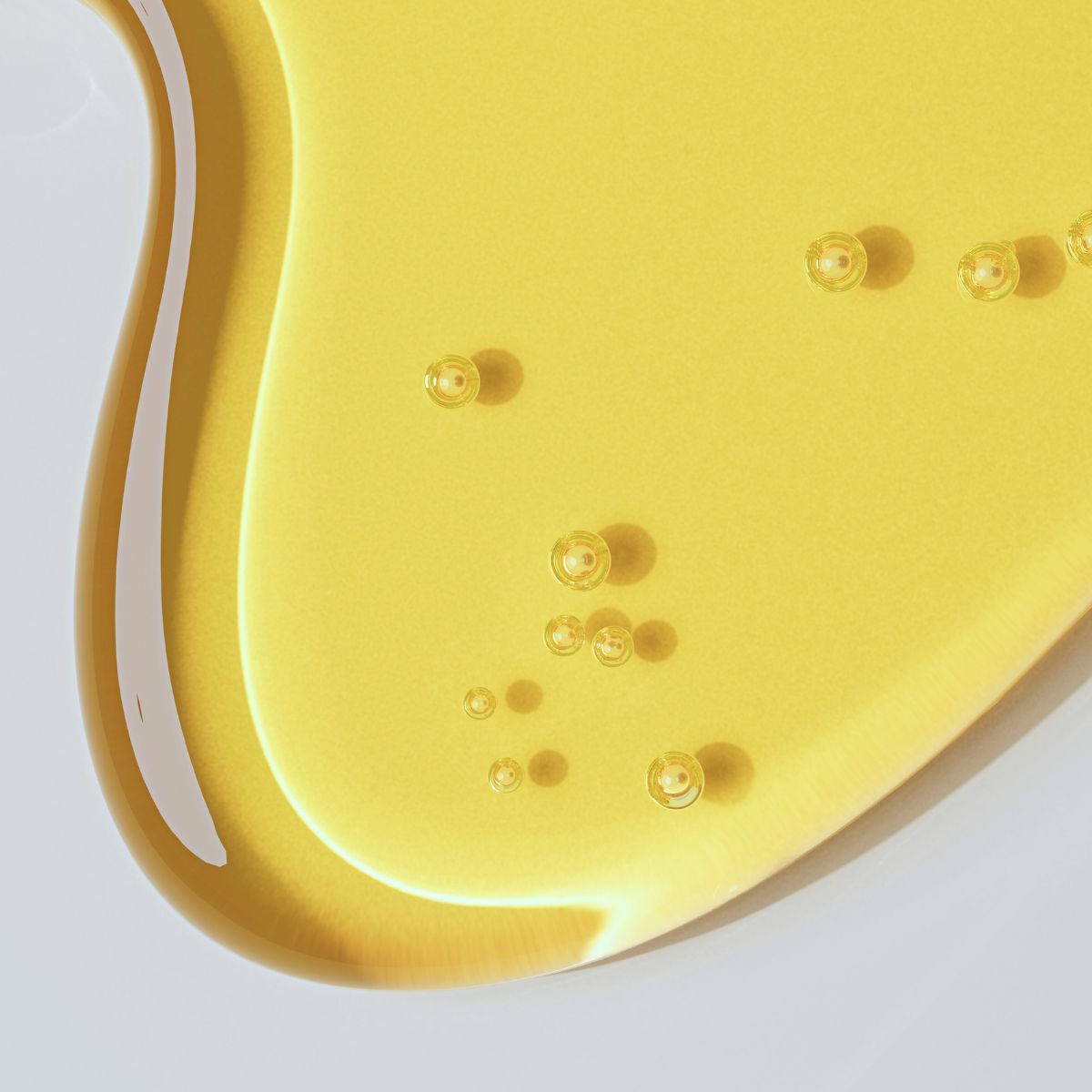 A golden oil drop representing oily skin and the balance needed to manage excess sebum and acne.